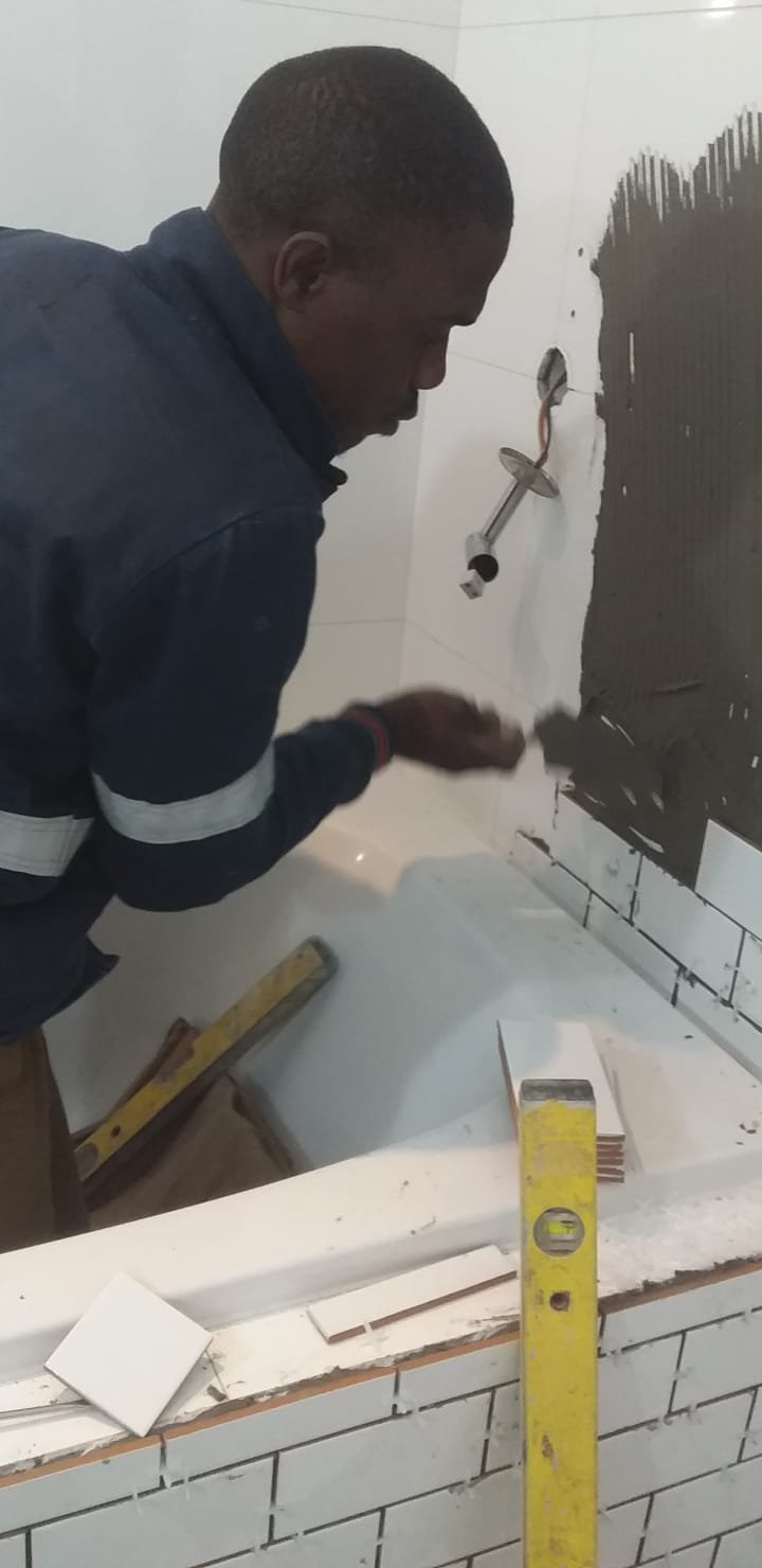 Technician tiling a wall